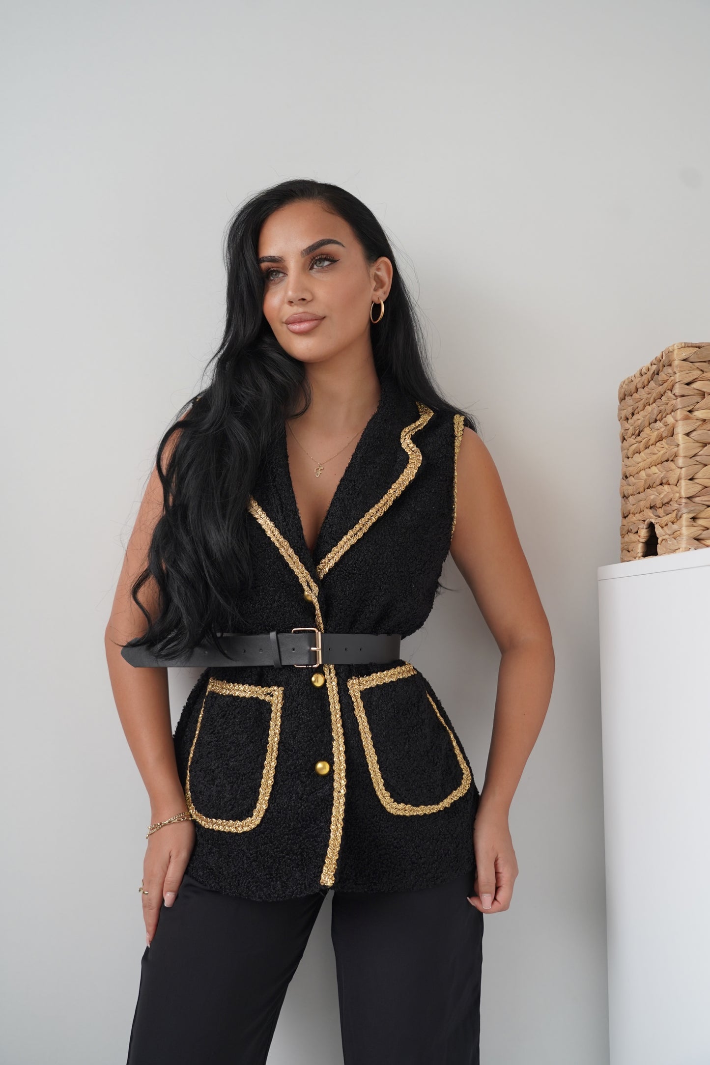 Elegant sleeveless black vest with golden braided trim