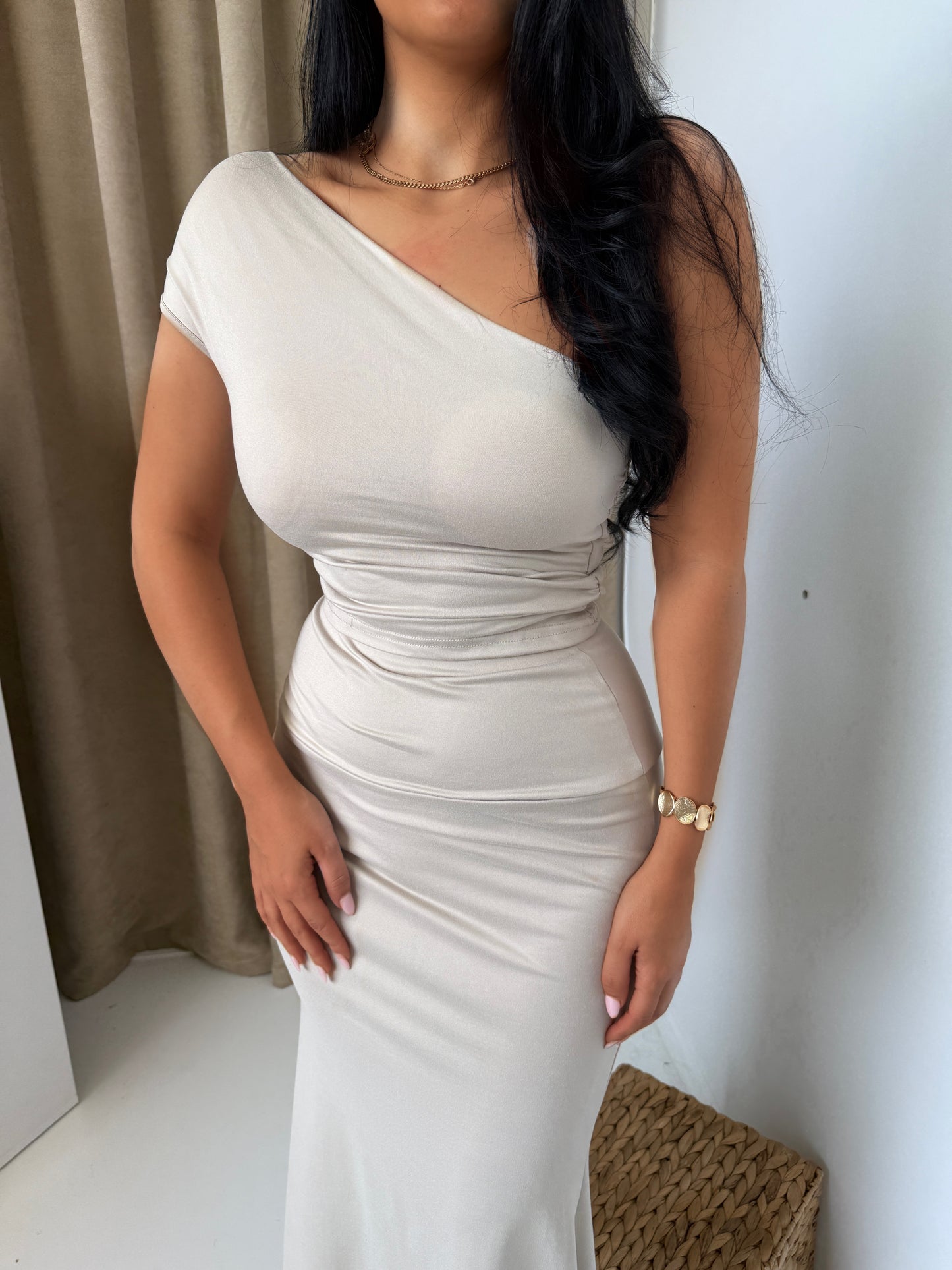 Beige two-piece set with a sleek one-shoulder top and a fitted mid-calf skirt