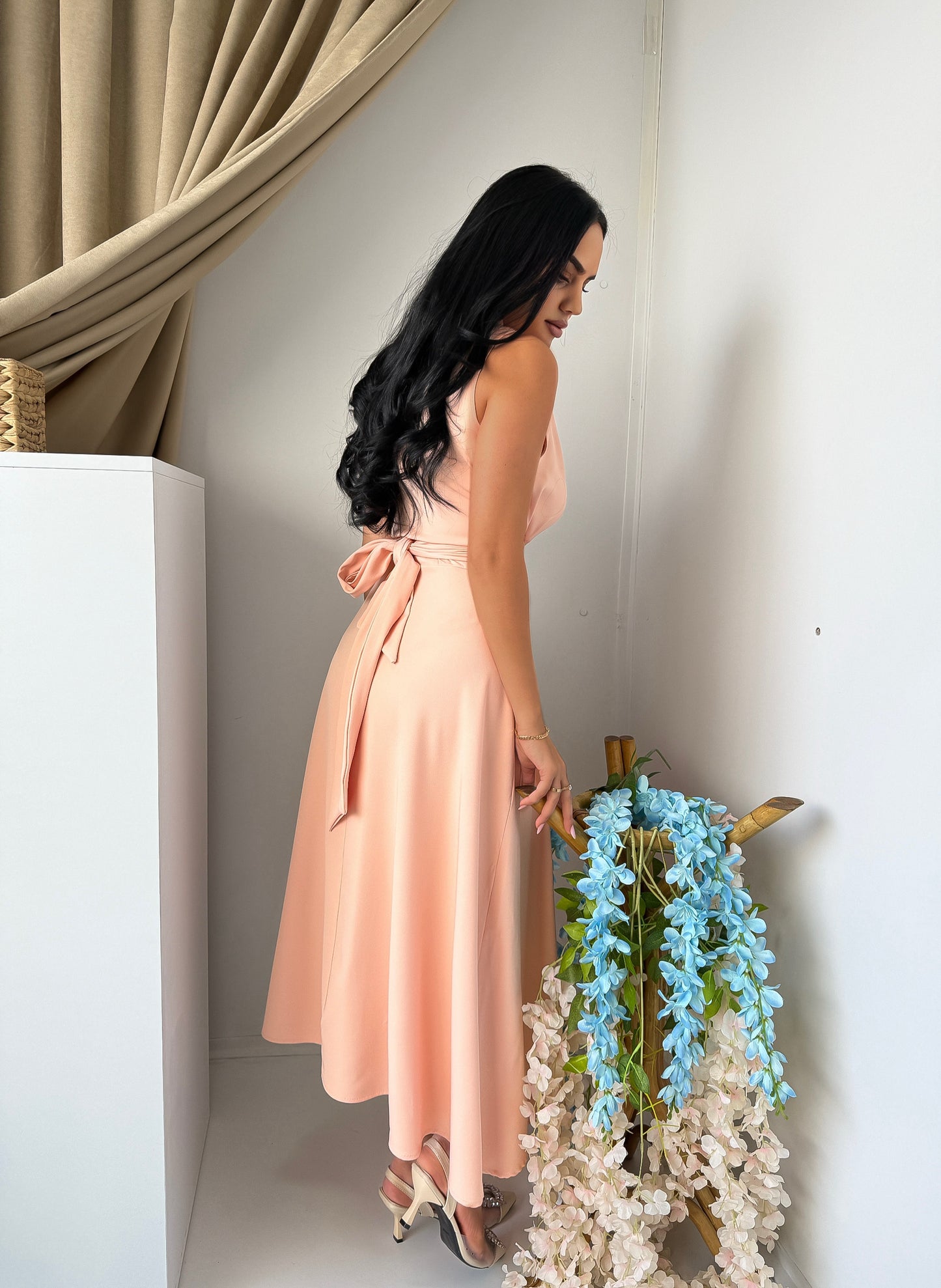 Soft and elegant sleeveless midi dress in a delicate blush pink tone.