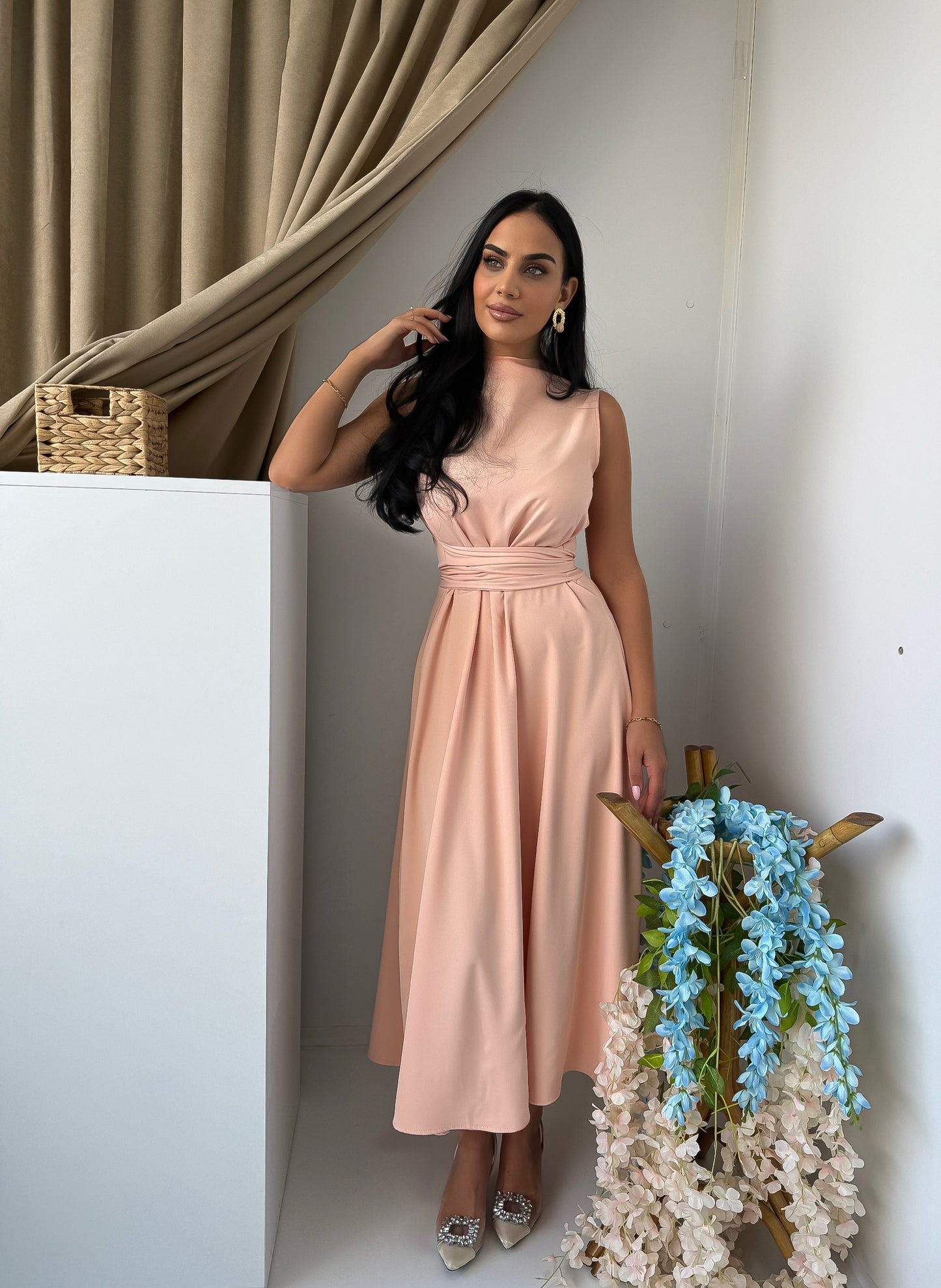Soft and elegant sleeveless midi dress in a delicate blush pink tone.
