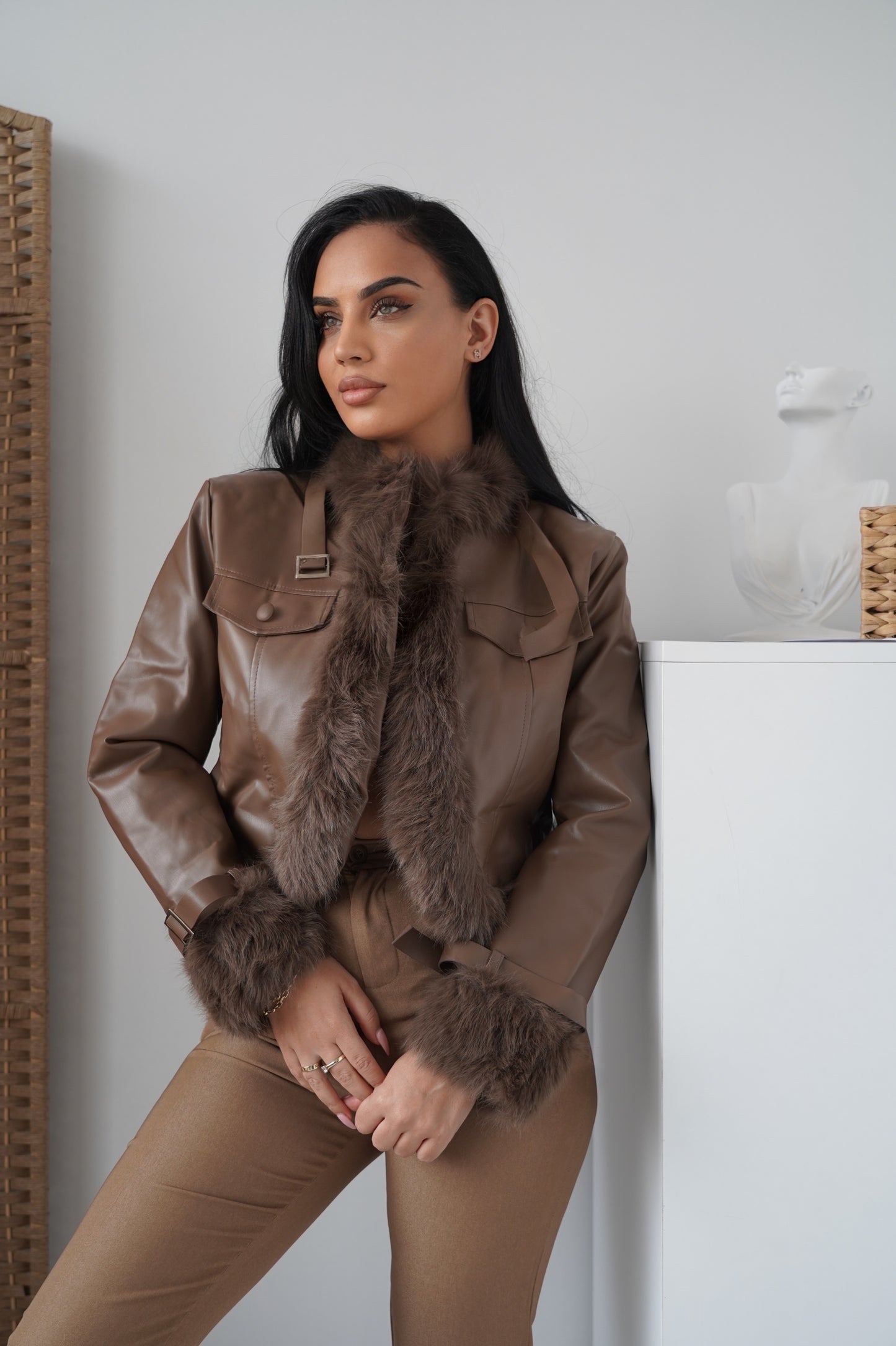 Modern faux leather jacket in brown, accented with faux fur details on the collar and cuffs.