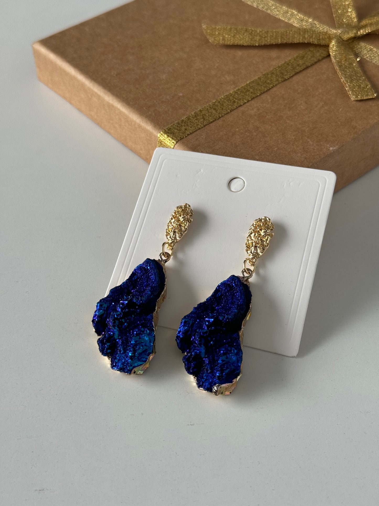 Bold and elegant, these earrings feature richly textured stones in a metallic deep blue tone