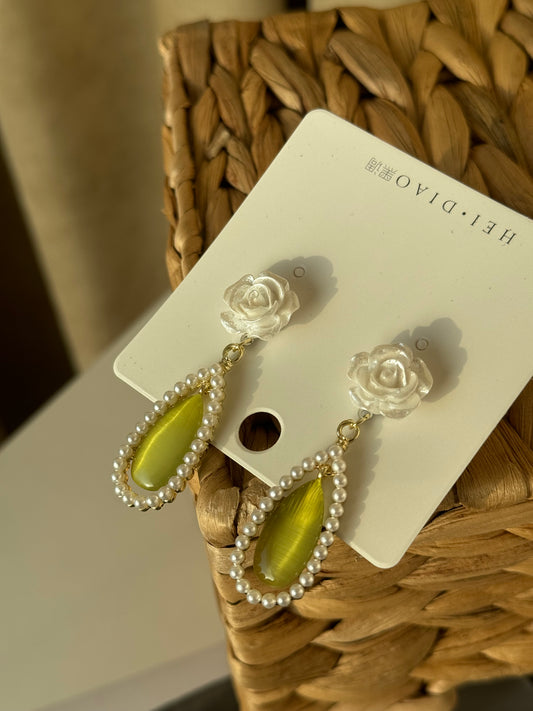 Soft rose, glowing green, and pearls that whisper elegance.