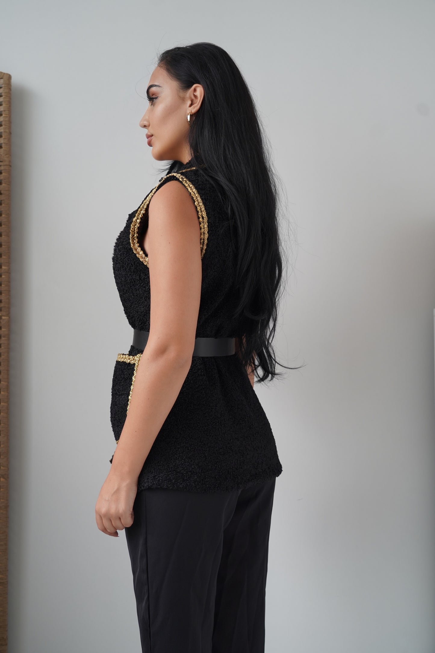 Elegant sleeveless black vest with golden braided trim