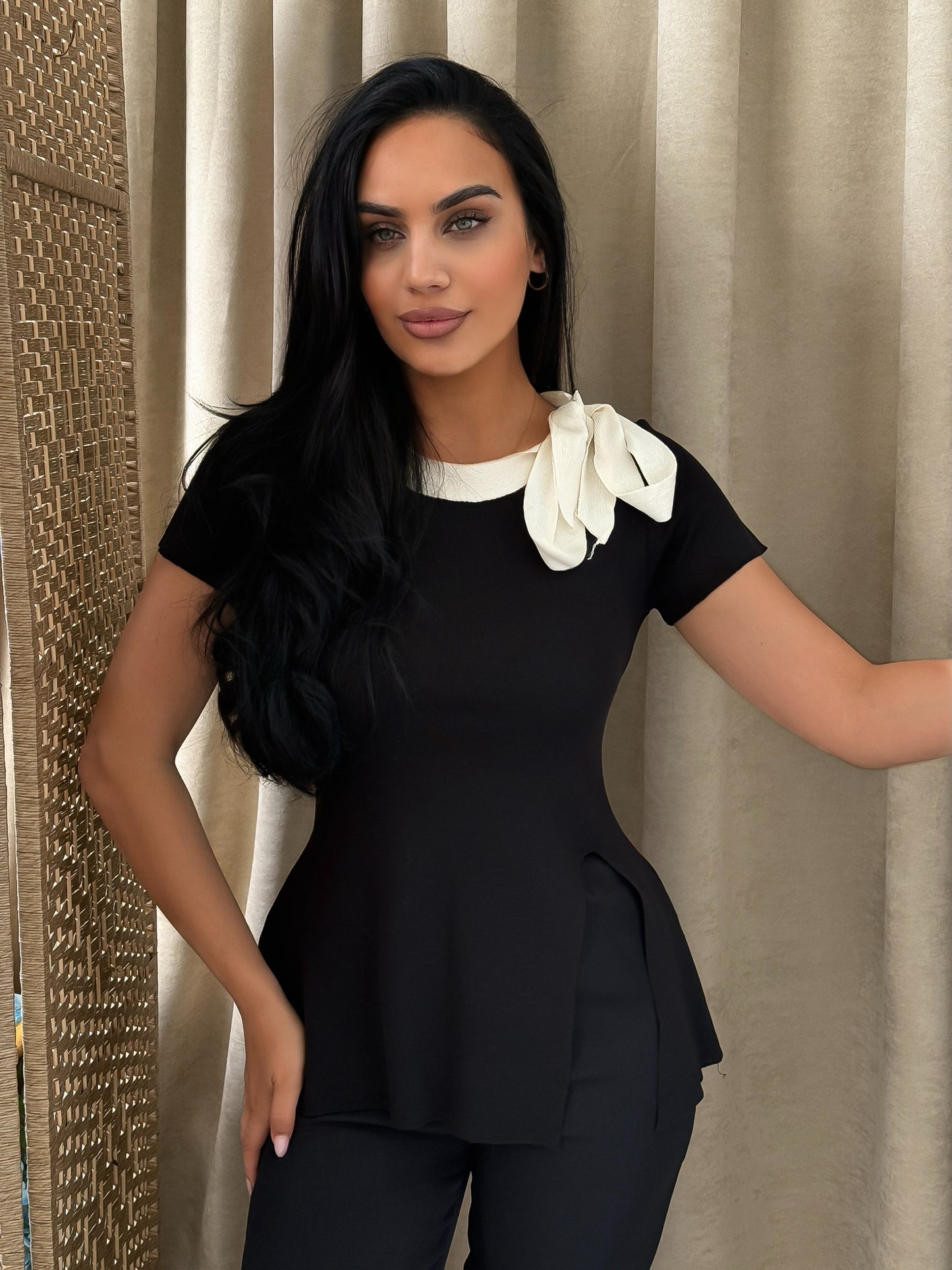 Elegant black blouse with a white collar and ribbon details perfect for formal and chic looks.